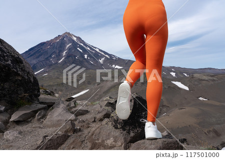 Closeup woman in figure hugging sports leggings showing off buttocks and legs. Athletic woman doing outdoor fitness training and her gluteal and thigh muscles are clearly defined. Rear view of body 117501000