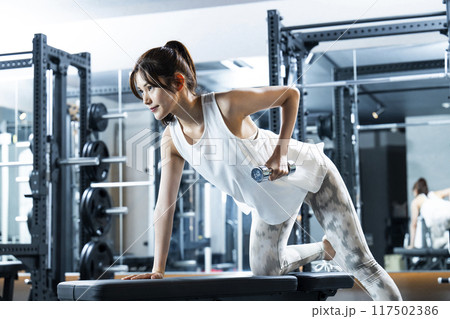 スポーツジムでトレーニングする若い女性 117502386