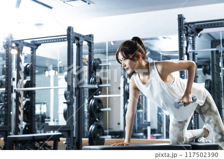 スポーツジムでトレーニングする若い女性 117502390