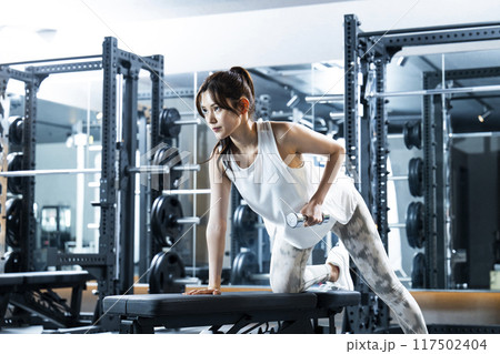 スポーツジムでトレーニングする若い女性 117502404
