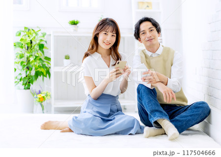 スマホを見る夫婦 117504666