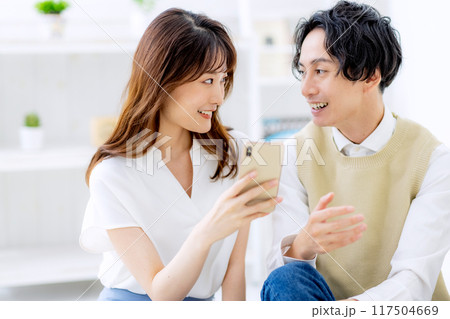 スマホを見る夫婦 スマホを見る夫婦 117504669