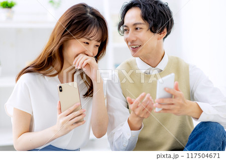 スマホを見る夫婦 117504671