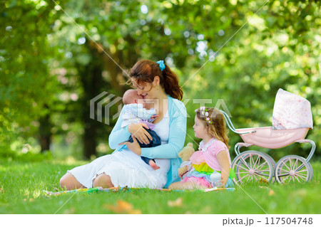 Mother and kids enjoying picnic outdoors Mother and kids enjoying picnic outdoors 117504748