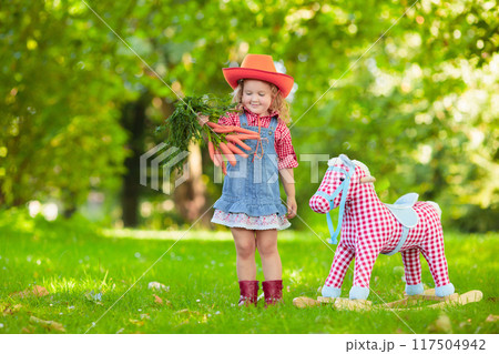 Cowboy kids playing with toy horse Cowboy kids playing with toy horse 117504942