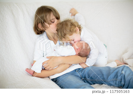 Siblings meet newborn baby in hospital 117505163