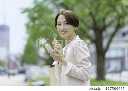 公園で口紅を治すミドルエイジの女性 117506635