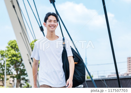 道路を歩く若い男性 117507703