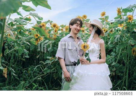 ひまわり畑で前踊りするカップル 117508603