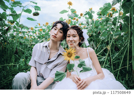 ひまわり畑で前踊りするカップル 117508649