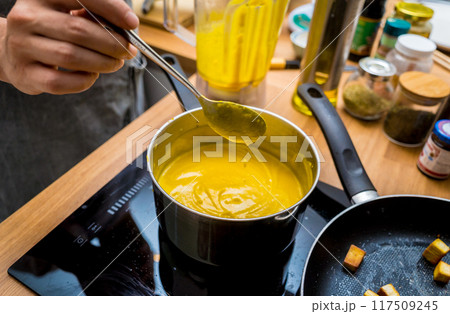 Chef at the kitchen preparing pumpkin porridge with tofu and vegetables Chef at the kitchen preparing pumpkin porridge with tofu and vegetables 117509245
