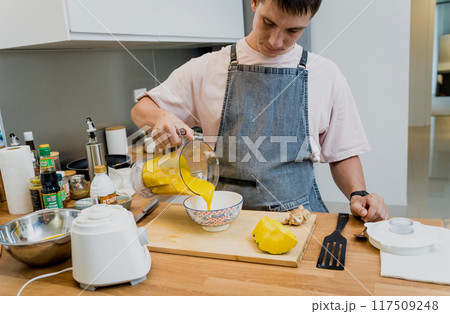 Chef at the kitchen preparing pumpkin porridge with tofu and vegetables 117509248