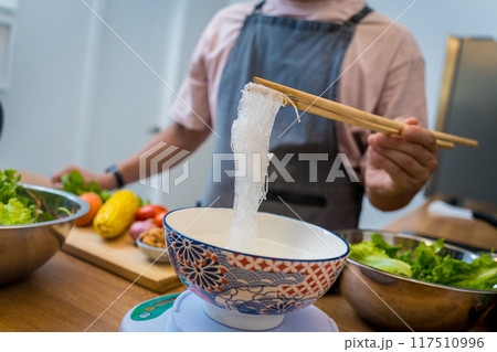 Chef at the kitchen preparing spicy glass noodle salad Chef at the kitchen preparing spicy glass noodle salad 117510996