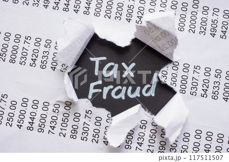 Torn financial report with the words Tax Fraud. Financial deception concept. Torn financial report with the words Tax Fraud. Financial deception concept. 117511507