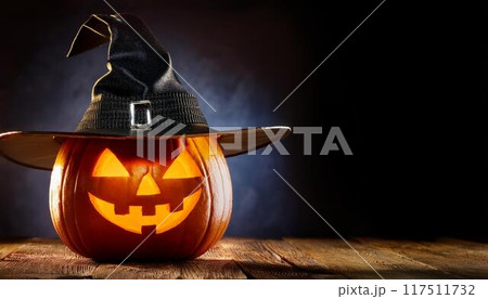 魔女の帽子をかぶった暗闇で光るハロウィンのカボチャ 117511732