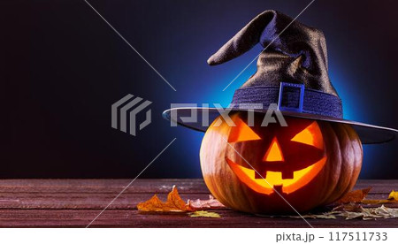 魔女の帽子をかぶった暗闇で光るハロウィンのカボチャ 117511733