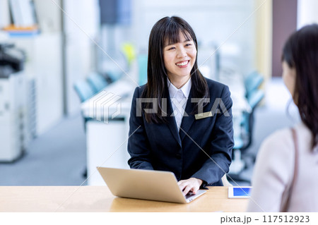 受付にいるスーツの女性に相談するイメージ 117512923