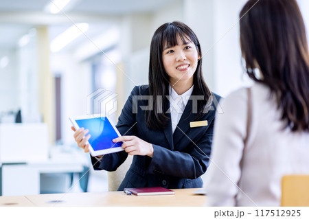 受付にいるスーツの女性に相談するイメージ 117512925