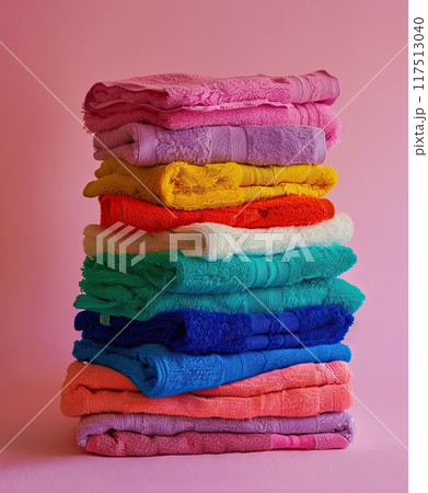 stack of multicolored towels on pink background 117513040