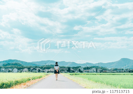 夏の田んぼ道を歩いていく三つ編みのセーラ服の女の子 夏の田んぼ道を歩いていく三つ編みのセーラ服の女の子 117513715