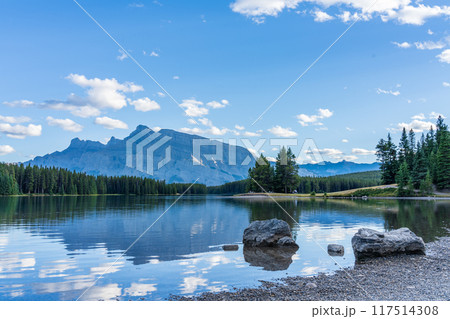 Two Jack Lake beautiful landscape in summer day. Mount Rundle with blue sky, white clouds reflected on water surface. Banff National Park, Canadian Rockies, Alberta, Canada. Two Jack Lake beautiful landscape in summer day. Mount Rundle with blue sky, white clouds reflected on water surface. Banff National Park, Canadian Rockies, Alberta, Canada. 117514308