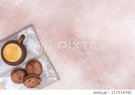Cup of coffee and chocolate macaroons on wooden board. Top view 117514392