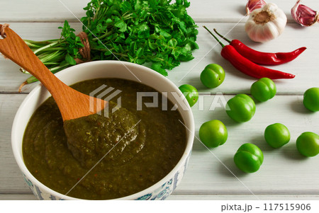 Tkemali sauce, traditional Georgian cuisine, green cherry plum, on a white wooden table, close-up, rustic, food background, no people, selective focus, 117515906
