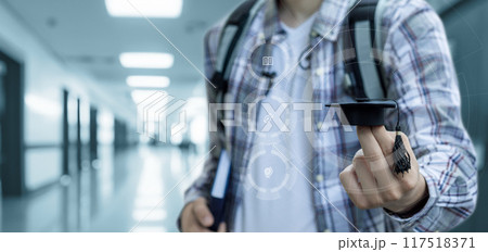 A student holds an academic cap on his finger. 117518371