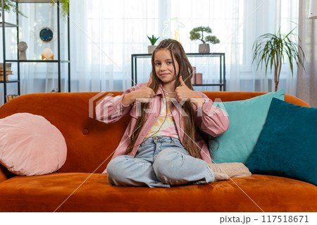 Child girl kid looking approvingly at camera showing double thumbs up like sign positive feedback Child girl kid looking approvingly at camera showing double thumbs up like sign positive feedback 117518671