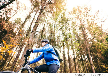 Active man on bike in the middle of beautiful nature, early autumn morning. Concept of healthy lifestyle. Low angle view 117519432