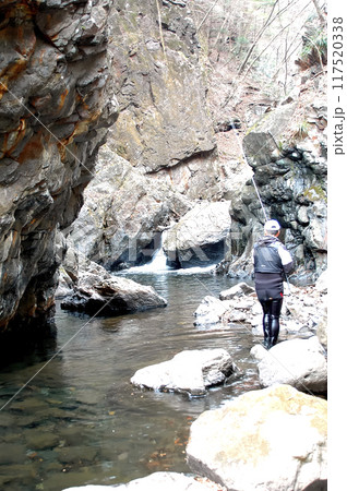 険しい渓流で渓流釣りを楽しむシニアの男性 117520338