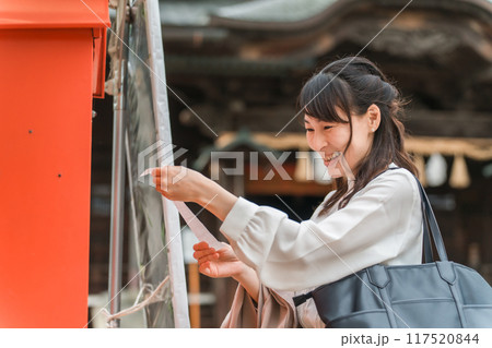 神社でおみくじを引くアジア人女性 神社でおみくじを引くアジア人女性 117520844