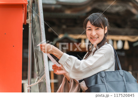 神社でおみくじを引くアジア人女性 117520845