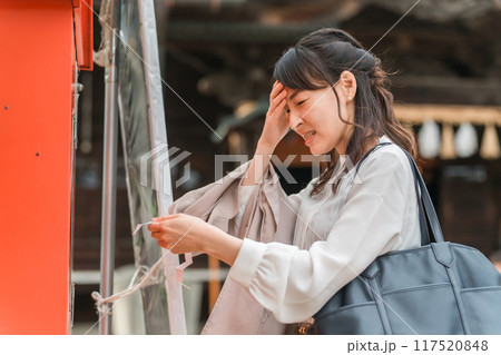 神社でおみくじを引くアジア人女性 117520848