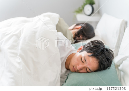 ベッドで眠る若い夫婦（快眠・安眠・熟睡） 117521398