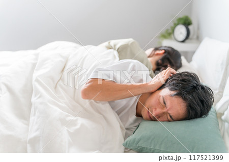 ベッドルームで妻のいびき・寝言に悩む夫(睡眠不足・寝れない・安眠妨害） 117521399