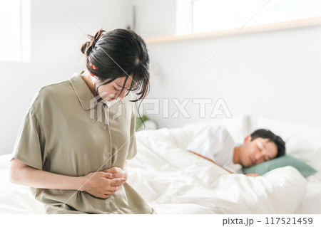 朝寝起きにベッドでお腹を抑える女性(妊娠・腹痛・つわり・妊活) 朝寝起きにベッドでお腹を抑える女性(妊娠・腹痛・つわり・妊活) 117521459