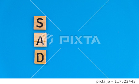 Seasonal affective disorder - text of wooden blocks on blue bright background. Concept of depression mood stress and anxiety. SAD Seasonal affective disorder - text of wooden blocks on blue bright background. Concept of depression mood stress and anxiety. SAD 117522445