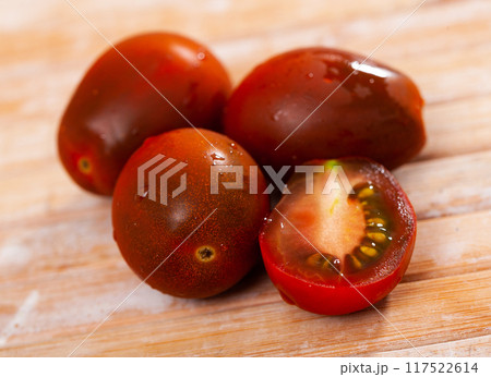 Close up of red ripe cherry tomato on table Close up of red ripe cherry tomato on table 117522614