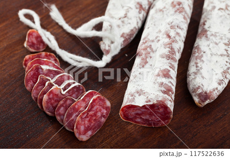 Spanish sausage fuet on a wooden table, closeup Spanish sausage fuet on a wooden table, closeup 117522636