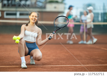 Young woman posing on tennis court 117522711