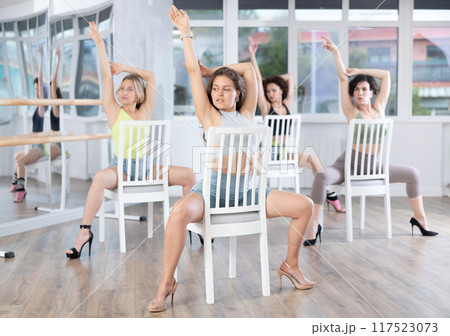 Sitting on chair, girl with long hair train to perform lap dance, interacting with imaginary partner 117523073