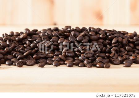Coffee beans on light wooden background Coffee beans on light wooden background 117523075