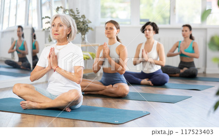 Yoga woman making yoga meditation in lotus pose in fitness studio 117523403