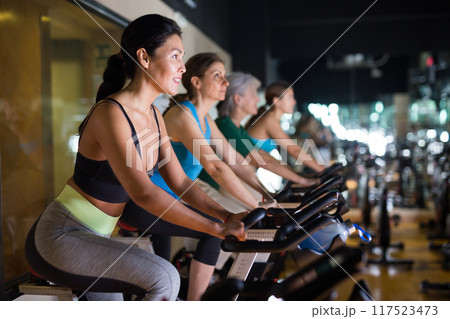 Asian woman with fitness bike in gym Asian woman with fitness bike in gym 117523473