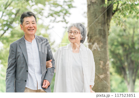 公園を話しながら歩く日本人の高齢者夫婦（シニア・男女） 117523851