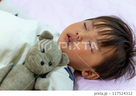 靴下ぬいぐるみを抱いて眠る2歳幼児の寝顔アップ 靴下ぬいぐるみを抱いて眠る2歳幼児の寝顔アップ 117524312