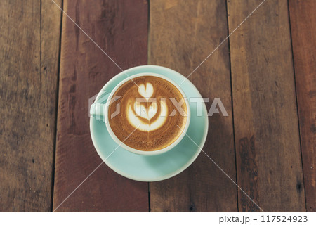Latte art coffee cup with milk on wooden table. Espresso shot make latte art hot coffee cup. Cappuccino with milk in italian coffee shop cafe. Brown hot caffeine beverage in cafeteria with copy space Latte art coffee cup with milk on wooden table. Espresso shot make latte art hot coffee cup. Cappuccino with milk in italian coffee shop cafe. Brown hot caffeine beverage in cafeteria with copy space 117524923