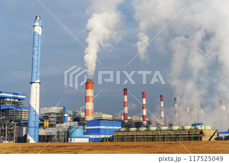 Power stations manufacturing electrical industrial plant. Electric power building refinery engineering smog steam smokestack. Lignite electricity chimneys release pollution in industry plant blue sky Power stations manufacturing electrical industrial plant. Electric power building refinery engineering smog steam smokestack. Lignite electricity chimneys release pollution in industry plant blue sky 117525049