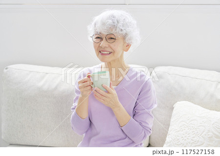 リビングルームでリラックスするシニア女性のポートレート 117527158